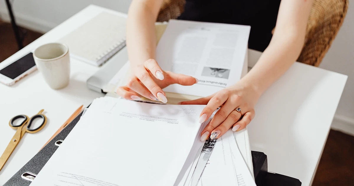Responsable RH qui classe des dossiers de demande de financement formation sur un bureau en bois, illustrant l'accès à la réserve nationale OPCO 2026